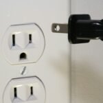 Close-up of electrical socket and plug illustrating generator outlet safety