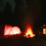 Glowing tent at a forest campsite illustrating small-load camping power planning