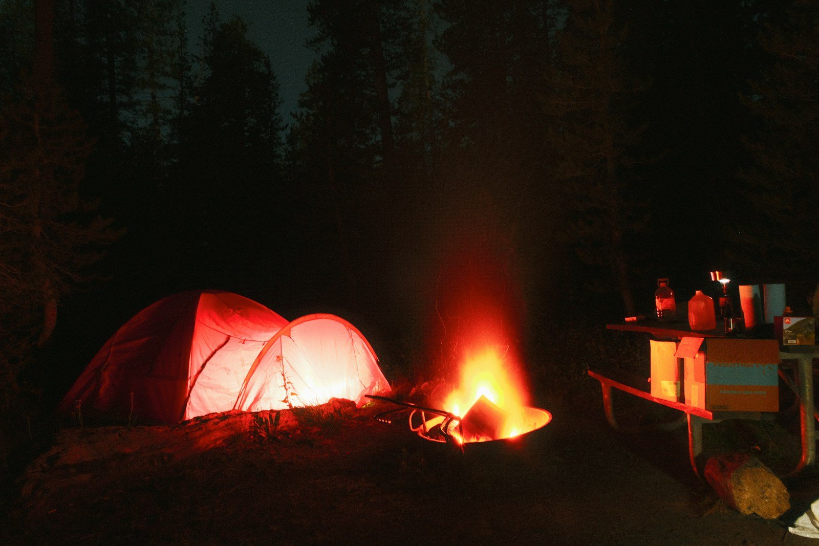 Glowing tent at a forest campsite illustrating small-load camping power planning