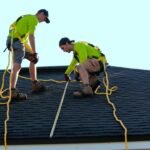 Solar installers working on a rooftop array illustrating safe series solar panel wiring and installation