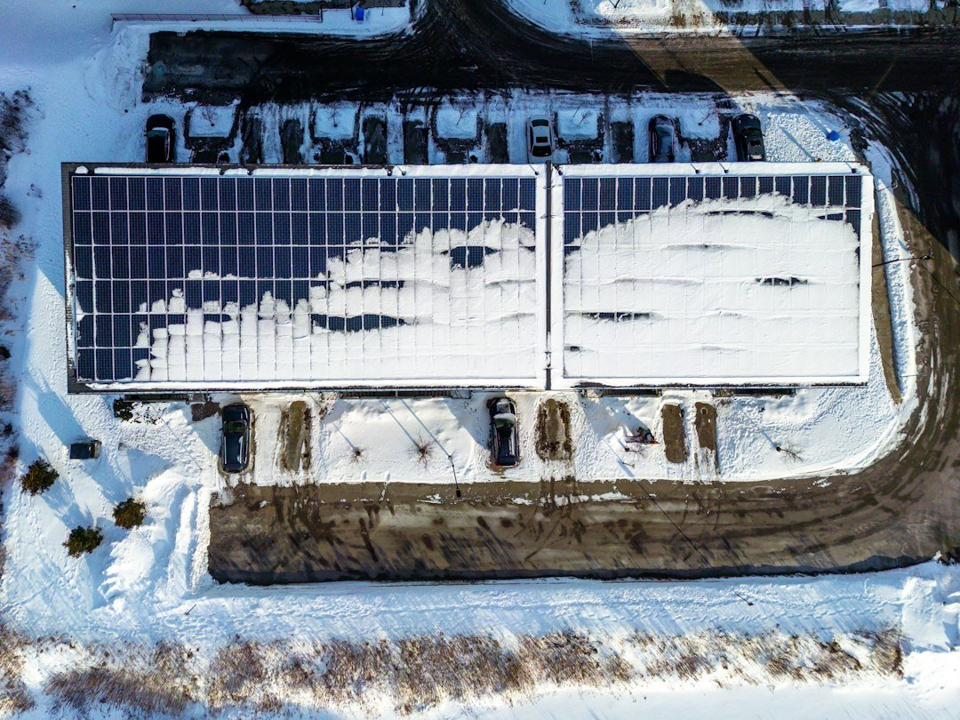 Rooftop solar panels partially covered with snow during winter weather