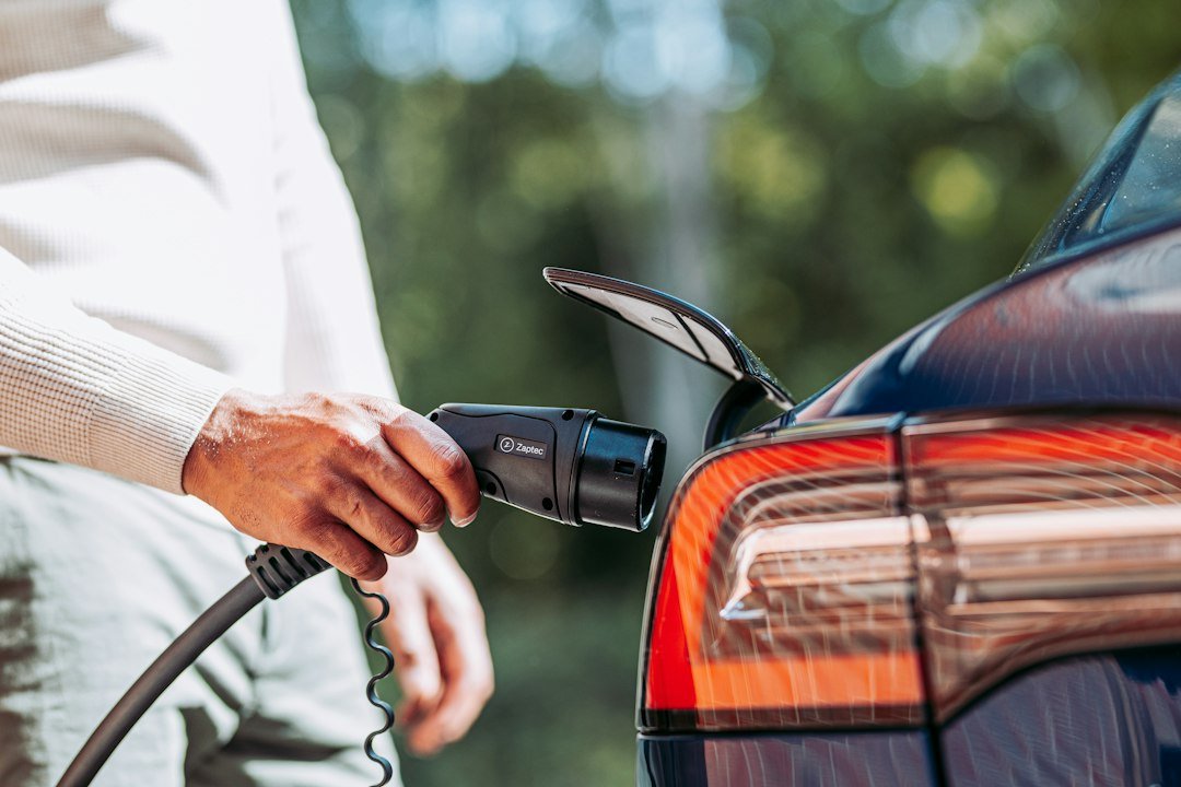 Tesla electric vehicle beside a home charging unit, illustrating how home solar electricity can be used for EV charging