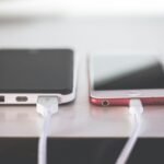 Portable USB battery pack beside a smartphone with charging cables connected