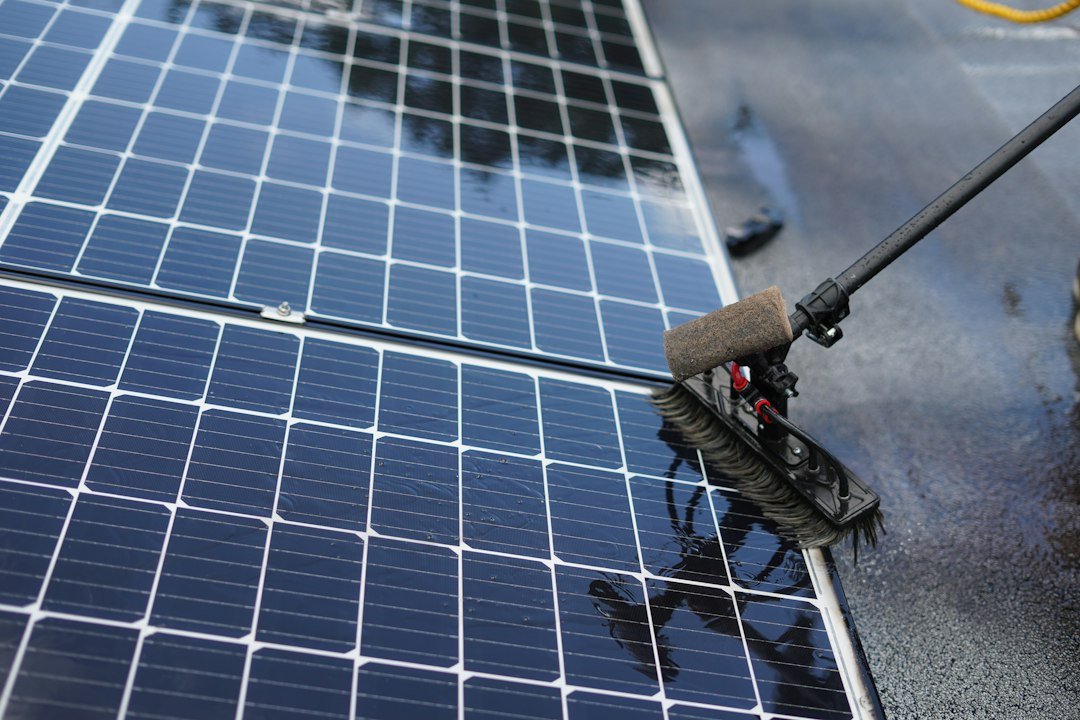 A brush cleans the glass surface of a solar panel