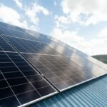Solar panels on a metal roof under a partly cloudy sky